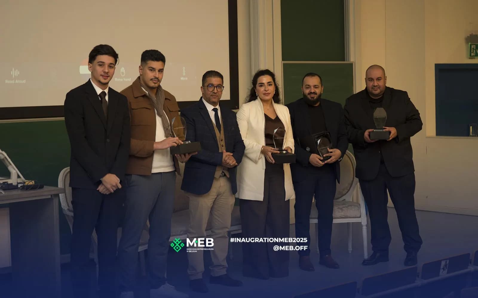 Photo de groupe sur scène, plusieurs intervenants tenant leur trophée.