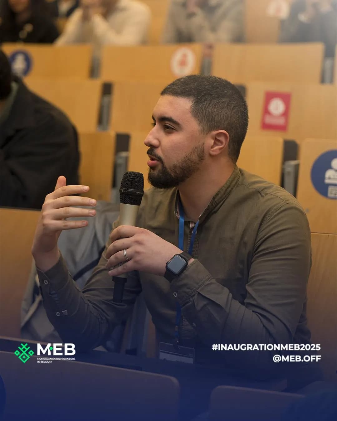 Un participant pose une question au micro depuis l’amphithéâtre.